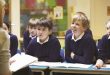 "Teacher leading a discussion with engaged students in a classroom."