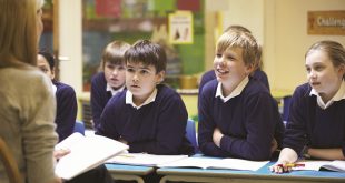 "Teacher leading a discussion with engaged students in a classroom."