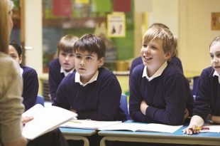 "Teacher leading a discussion with engaged students in a classroom."