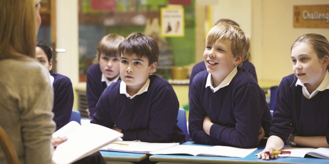 "Teacher leading a discussion with engaged students in a classroom."